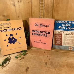 May include: Three vintage mathematics books. The book on the left is titled "Games for Learning Mathematics" with a child illustration. The middle book is titled "One Hundred Mathematical Curiosities." The book on the right is titled "Advanced Algebra and Calculus Made Simple."