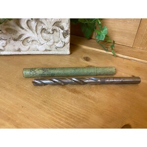 May include: A vintage drill bit in a green paper tube. The tube has the text "Straight Shank Drill Taper Length" printed on it.