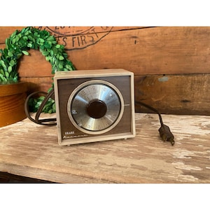 May include: A vintage brown and beige Sears timer with a round dial and a black knob. The timer has a cord and plug.