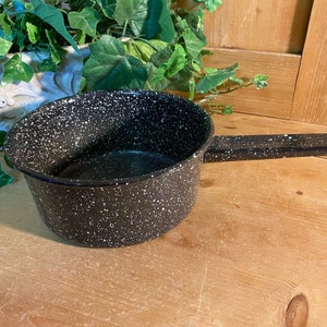 May include: Black speckled saucepan with a black handle. The saucepan is made of metal and has a speckled finish.