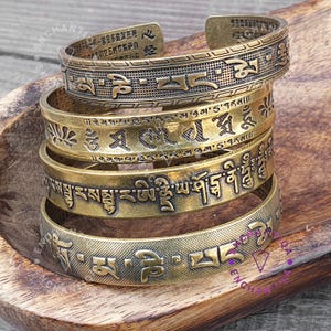 Braccialetti portafortuna in ottone antico vintage con scritture buddiste incise in sanscrito, sutra e mantra buddisti, realizzati a mano in quattro pezzi. Braccialetto rigido buddista in ottone anticato.