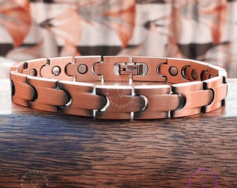 May include: A copper-colored magnetic bracelet with a brushed finish. The bracelet is made of multiple linked pieces and has a magnetic clasp.