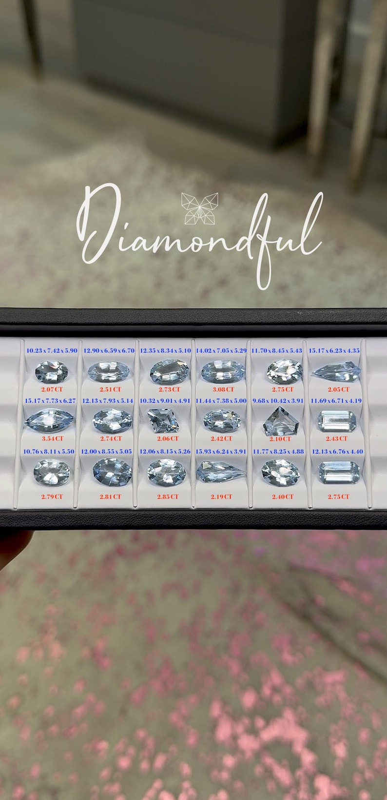 Op de afbeelding: Een vitrine met verschillende aquamarijn edelstenen. Elke edelsteen heeft een andere slijpvorm en grootte, met afmetingen in mm en karaatgewichten. Het woord "Diamondful" staat in sierlijke letters bovenaan.