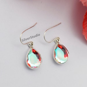 May include: A pair of silver teardrop earrings with iridescent red and blue gemstones.