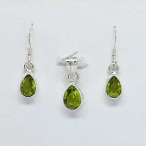 May include: A set of silver earrings and a pendant featuring pear-shaped green gemstones.