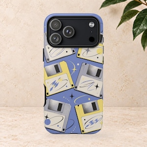 Peut inclure: Une coque de smartphone avec un motif répétitif de disquettes jaunes et grises sur un fond bleu pervenche. Le design comprend de petits graphismes d'étoiles et de planètes blanches dispersés entre les disquettes, avec une découpe noire.