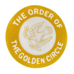 May include: A gold circle patch with the text "The Order of the Golden Circle" in white lettering. Inside the circle is a white dove with the words "Peace" and "Unity" on banners.
