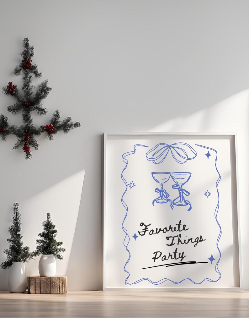 Op de afbeelding: Een witte ingelijste print met een blauwe illustratie van twee glazen met een blauw lint en de tekst "Favorite Things Party" in zwarte cursieve letters.