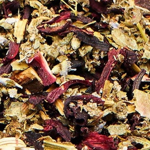 May include: A close-up of a blend of dried herbs and flowers, including hibiscus, lavender, and other botanicals. The mixture is a vibrant mix of red, purple, and green hues.
