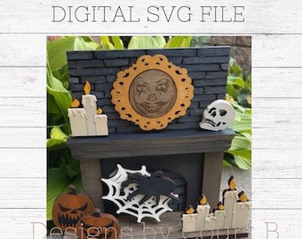 Puede incluir: Un archivo SVG digital para una chimenea de Halloween con una cara espeluznante en un espejo, una telaraña, una calavera y calabazas. La chimenea está hecha de madera y tiene un patrón de ladrillo blanco y negro. El texto "Designs by Court B" está en la parte inferior de la imagen.
