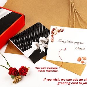Op de afbeelding: Een cadeau set met een zwart-witte polkadot doos met een zilveren strik, een rood-zwarte doos en een wenskaart met de tekst "Happy birthday my love Stewart". Inclusief rode rozen en een gouden accent.