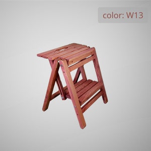Può includere: Uno sgabello a gradini in legno con due gradini, dipinto di colore marrone rossiccio. Lo sgabello è piegato e ha un piccolo foro nel gradino superiore. Il testo "color: W13" è visibile nell'angolo in alto a destra dell'immagine.