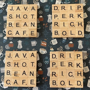 Peut inclure: Quatre sous-verres en bois avec les mots "JAVA, SHOT, BEAN, CAFE", "DRIP, PERK, RICH, BOLD", "JAVA, SHOT, BEAN, CAFE", et "DRIP, PERK, RICH, BOLD" écrits en lettres noires.
