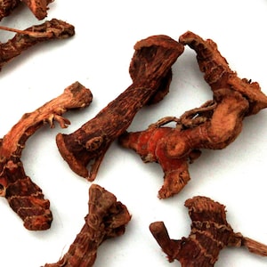 Peut inclure: Morceaux de racine de gingembre séchée, une épice naturelle utilisée en cuisine et dans les remèdes à base de plantes. Les morceaux sont bruns et ont une texture rugueuse.
