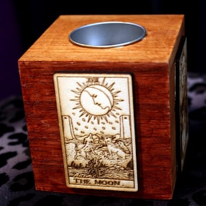 May include: A wooden box with a cutout for a candle or incense. The front of the box features a tarot card with the image of the moon and the text "THE MOON".