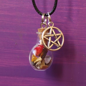 Puede incluir: Un dije de pentáculo plateado cuelga de un collar de cordón negro. El pentáculo está unido a una pequeña botella de vidrio llena de varios cristales y piedras.