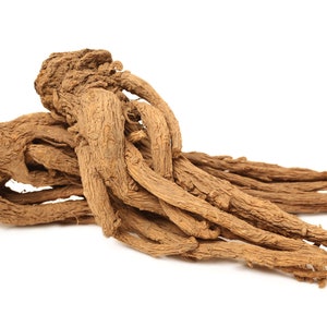 Pode incluir: Uma aproximação de uma coleção de raízes marrons secas contra um fundo branco. As raízes têm uma superfície áspera e texturizada e variam em espessura, com algumas parecendo mais grossas e bulbosas do que outras. As raízes são provavelmente usadas para fins medicinais ou culinários.