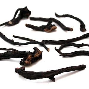 May include: A collection of dried black roots, some with a brown, woody texture, scattered on a white background.