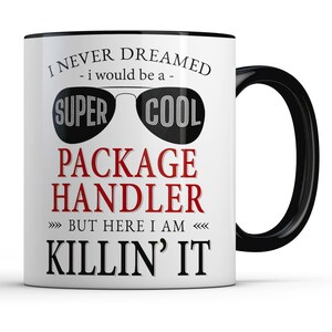 May include: White ceramic coffee mug with a black rim and handle. The mug has a funny saying that reads "I never dreamed - I would be a - super cool package handler but here I am killin' it".