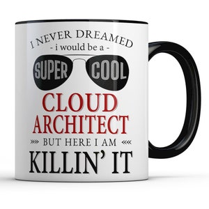 May include: White coffee mug with a black rim and handle. The mug has a red and black design that says "I never dreamed - I would be a - super cool cloud architect but here I am killin' it".