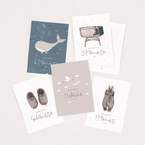 May include: Five illustrated cards with watercolor designs for a baby's first year. The cards feature a whale, a crib, a stork, baby shoes, and overalls. Each card has text that says "Heute bin ich" followed by the age in weeks or months. The cards are on a white background.