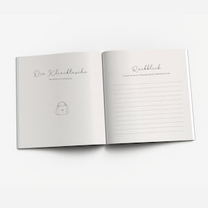 May include: A blank journal with a white cover and black text. The left page has the title "Die Kliniktasche" and a drawing of a small bag. The right page has the title "R&uuml;ckblick" and lined paper for writing.