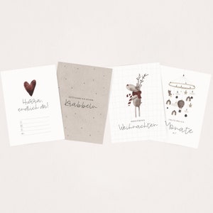 May include: Four printable cards with illustrations and text. The first card is white with a red heart and the text "Hurra. endlich da!" The second card is brown with the text "JETZT KANN ICH SCHON Krabbeln". The third card is white with a grid pattern and a reindeer illustration with the text "MEIN ERSTES Weihnachten". The fourth card is white with a mobile illustration and the text "HEUTE BIN ICH Monate ALT".