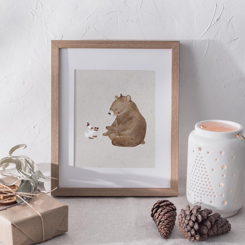 May include: A framed illustration of a brown bear sitting and looking at a small white rabbit with a red scarf. The illustration is on a light brown background.