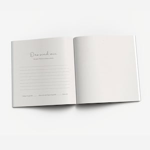May include: An open book with a white cover and lined pages. The text on the cover reads "Das sind wir" and "Ein paar Worte zu unserem Leben".