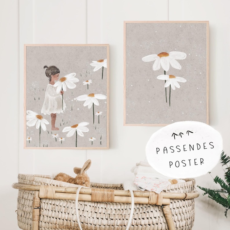 May include: Two framed prints with a gray background and white daisies. The print on the left shows a girl in a white dress holding a daisy. The print on the right shows a single daisy with three stems.