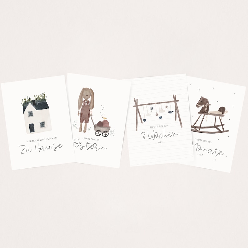 May include: Four illustrated cards with watercolor designs. The first card features a house with a green roof and the text "Herzlich Willkommen Zu Hause". The second card features a bunny holding a basket of eggs with the text "Mein Erstes Ostern". The third card features a mobile with the text "Heute bin ich 3 Wochen alt". The fourth card features a rocking horse with the text "Heute bin ich Monate alt."