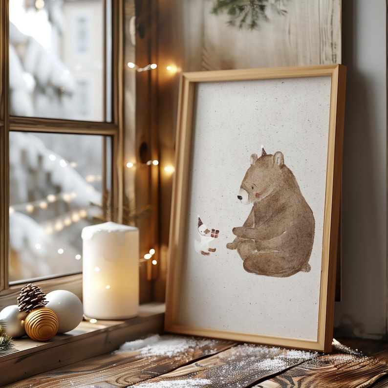 May include: A framed illustration of a brown bear sitting and looking at a small white animal with red accents. The background is a light brown with a subtle texture. The frame is a light brown wood.