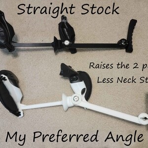Może przedstawiać: Dwa regulowane czarno-białe urządzenia z tekstem "Straight Stock" i "My Preferred Angle". Widoczny jest r&oacute;wnież tekst "Raises the 2 pc Base Less Neck Strain". Urządzenia wydają się być zaprojektowane do podpierania głowy użytkownika.