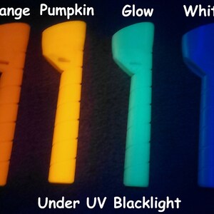 May include: Four glow sticks in different colors: orange, yellow, green, and blue. The glow sticks are under a UV blacklight.