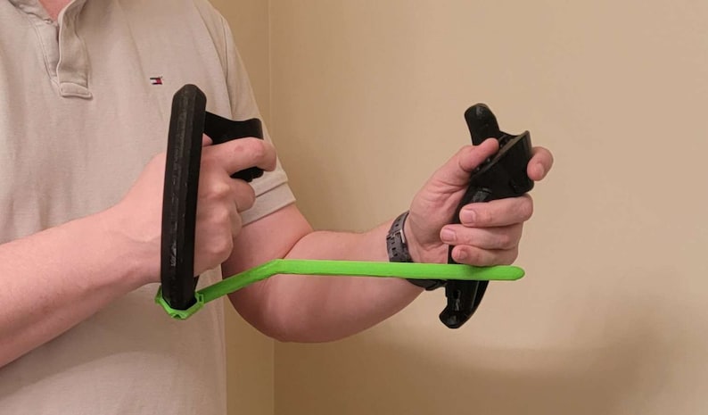 May include: A person is holding two black 3D printed hand grips connected by a bright green bar.
