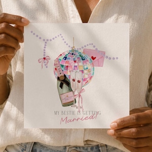 Op de afbeelding: Een vierkante wenskaart met een aquarelillustratie van een discobal, een champagnefles, twee glazen en een roze envelop. De tekst luidt MY BESTIE IS GETTING Married! met een snoer van lichtpaarse kralen en een klein roze strikje.
