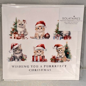 May include: A Christmas card featuring six adorable kittens wearing Santa hats. The kittens are surrounded by presents and Christmas trees. The card reads "Wishing you a purrrfect Christmas".