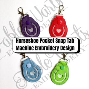 May include: Four horseshoe-shaped keychains in purple, red, blue, and green. Each keychain features a horseshoe design with a heart in the center and a snap tab closure. The text "Horseshoe Pocket Snap Tab Machine Embroidery Design" is displayed.