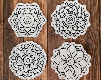 May include: Four white round coasters with black mandala designs. The coasters are made of a soft, absorbent material and are ideal for protecting your furniture from spills and scratches.