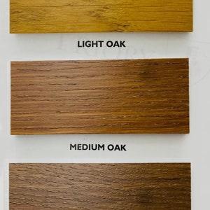 Puede incluir: Tres muestras de madera que muestran diferentes tonos de roble: roble claro, roble medio y roble oscuro.