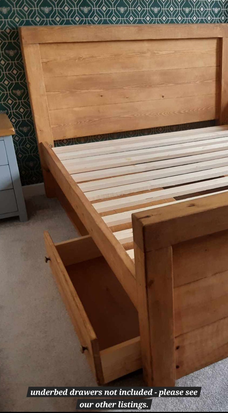 Puede incluir: Una estructura de cama de madera con cabecero y un caj&oacute;n abierto. La estructura de la cama es de madera de color claro y tiene una base de listones. El cabecero est&aacute; hecho de tablones de madera horizontales. El texto en la parte inferior dice "cajones bajo la cama no incluidos - consulte nuestros otros listados."