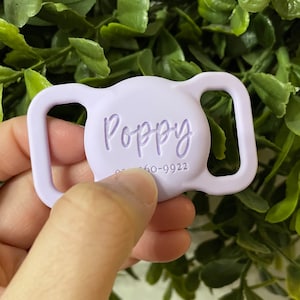 May include: A lavender silicone adjustable buckle with the name "Poppy" engraved on the front.