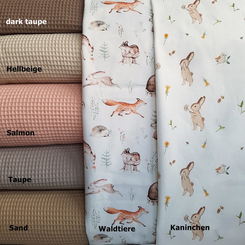 May include: Five different colors of waffle fabric swatches, from dark taupe to sand. The fabric is displayed next to two fabric swatches with different animal prints. One fabric features a white background with brown foxes, deer, and hedgehogs. The other fabric features a white background with brown rabbits and the text "Kaninchen". The text "Waldtiere" is printed on the fabric with the foxes, deer, and hedgehogs.
