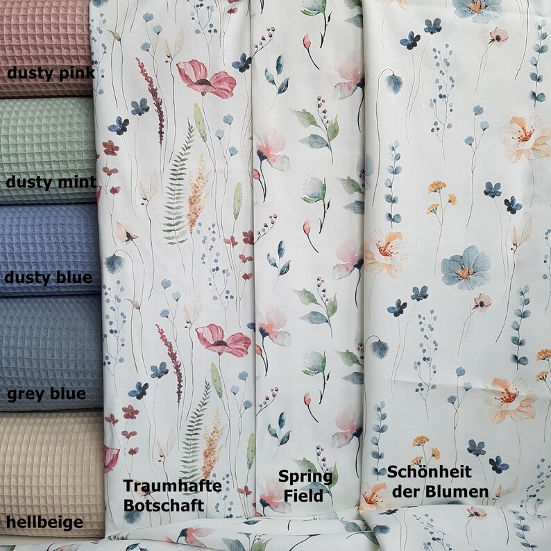 May include: A close-up of four fabric swatches with different colors and textures. The swatches are labeled "dusty pink", "dusty mint", "dusty blue", "grey blue", and "hellbeige". The fabric swatches are next to three fabric samples with watercolor floral patterns. The floral patterns are labeled "Traumhafte Botschaft", "Spring Field", and "Sch&ouml;nheit der Blumen".