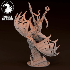 Op de afbeelding: Een gedetailleerd, lichtgekleurd beeldje van een gevleugelde demonenstrijder, dynamisch geposeerd op een grafsteen. De figuur houdt een zwaard en een staf vast. De vleugels zijn groot en gedetailleerd. Het logo "FOREST DRAGON" staat linksboven.