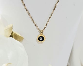 Könnte beinhalten: Eine goldene Kettenkette mit einem kleinen schwarzen und weißen bösen Augen-Anhänger.
