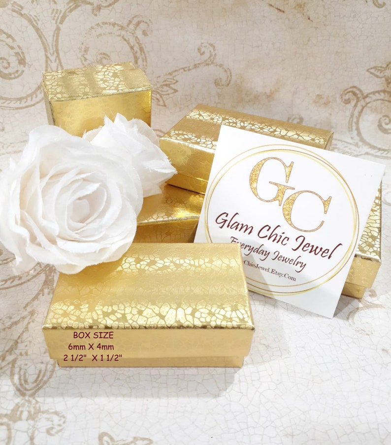 May include: Gold jewelry boxes with a textured pattern. The boxes are stacked on top of each other. The top box has a white label with the text "Glam Chic Jewel Everyday Jewelry GlamChicJewelEtsy.com". The box size is 6mm x 4mm or 2 1/2" x 1 1/2".