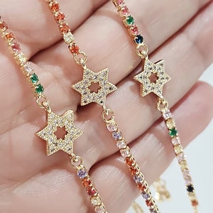 May include: Three gold bracelets with colorful crystal accents and a star charm. Each bracelet features a different color scheme.