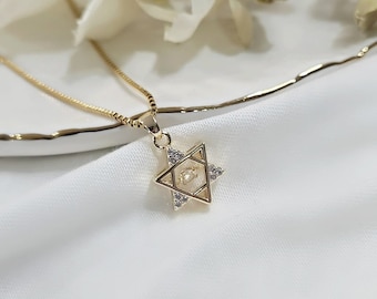 May include: A gold chain necklace with a pendant in the shape of a Star of David with clear cubic zirconia stones.