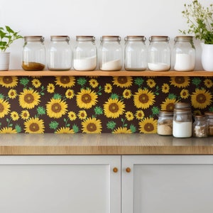 Può includere: Un rivestimento da cucina con sfondo marrone e un motivo ripetitivo di girasoli gialli con foglie verdi.